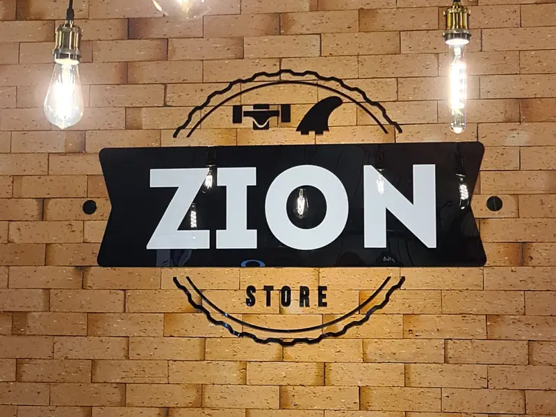 Logotipo da Zion Store em acrílico sobre parede de tijolo