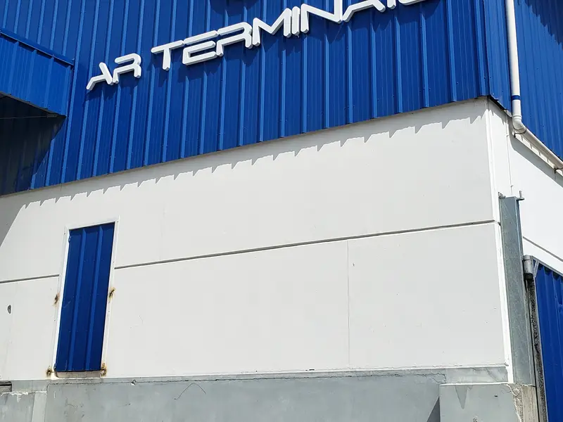 Letreiro em letra caixa da AR Terminais em fachada de galpão